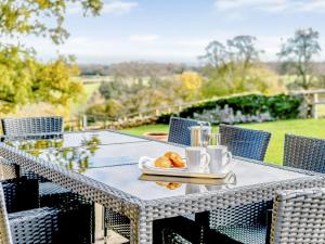 a table with a plate of croissants and coffee cups at Owl Barn -- Uk30757 in Bream