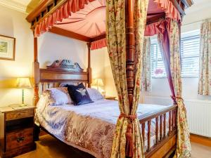 a bedroom with a four poster canopy bed at The Pigsty - Uk30945 in Barthomley