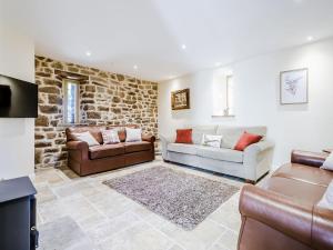 a living room with two couches and a stone wall at Owl Barn -- Uk30757 in Bream
