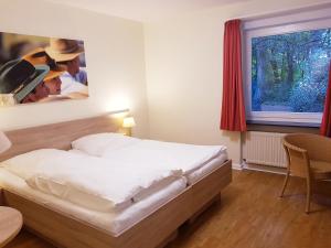 een slaapkamer met een groot bed en een schilderij aan de muur bij Christian Jensen Kolleg und Gästehäuser in Breklum