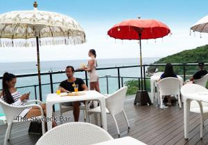 a group of people sitting at tables on a deck at Fairways and Bluewater Boracay in Boracay