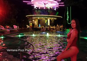 a woman in a red dress sitting in a pool at night at Fairways and Bluewater Boracay in Boracay