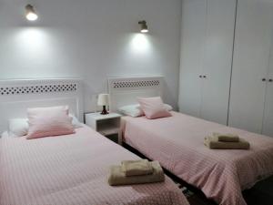 two beds in a room with pink and white at Casa Alisios in Playa de Santiago