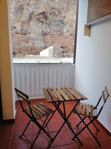 a wooden table and two chairs next to a window at Casa Alisios in Playa de Santiago