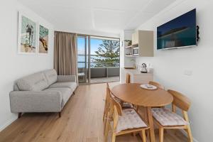 a living room with a table and a couch at The Mid Pacific in Port Macquarie