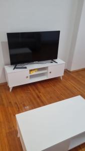 un centro di intrattenimento bianco con TV a schermo piatto di Erdem Apartment ad Atakum