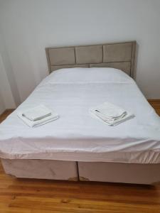 ein Bett mit weißer Bettwäsche und weißen Handtüchern darauf in der Unterkunft Erdem Apartment in Atakum