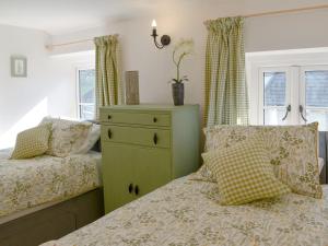 a bedroom with a green dresser and a bed at Fern Cottage in Bradwell