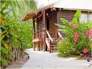 a wooden cabin with a porch and some pink flowers at Sokala Villas in Muri