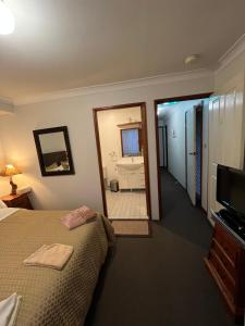 a bedroom with a bed and a mirror and a bathroom at JOHN HUNTER B&B in Lambton