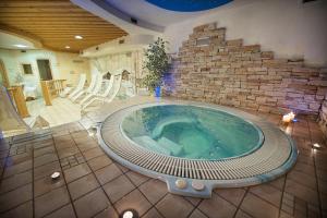 a hot tub in a room with a brick wall at Hotel Valtellina in Livigno