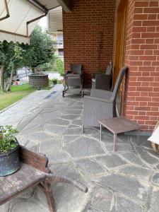 a patio with chairs and a bench on a brick wall at Da Gegè in La Loggia