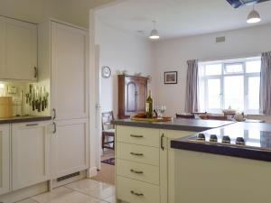 a kitchen with white cabinets and a sink and a window at Sunray - Uk31515 in Dale