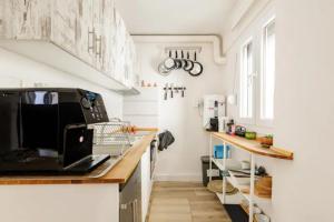 Lovely small (parterre) apartment in Thessaloniki في سلانيك: مطبخ مع كونتر عليه لاب توب