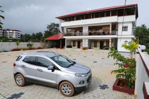 a small car parked in front of a building at Castle home stays in Udupi