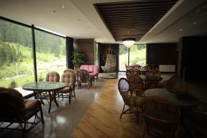 un ristorante con tavoli e sedie e una grande finestra di PAZARCIK MOUNTAIN HOTEL a Trabzon