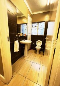 Juke's Serene Westlands Villa في نيروبي: حمام مع مرحاض ومغسلة