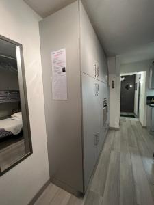 einen Flur mit einem Kühlschrank und ein Zimmer mit einem Bett in der Unterkunft Coquet et accueillant Studio montagne la Mongie in Bagnères-de-Bigorre