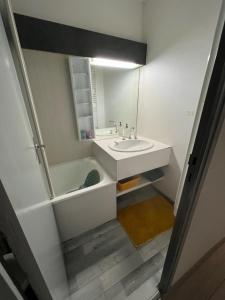 ein Badezimmer mit Waschbecken, Badewanne und Spiegel in der Unterkunft Coquet et accueillant Studio montagne la Mongie in Bagnères-de-Bigorre + 25 Fotos