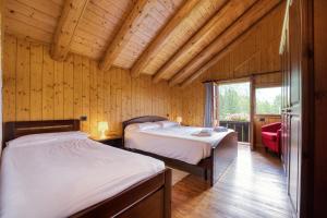 1 dormitorio con 2 camas en una cabaña de madera en Incanto Walser Apartments Testa, en Macugnaga