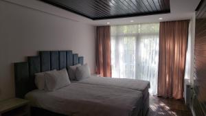 a bedroom with a large bed and a large window at Basharu resort in Lankaran