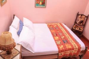 a bedroom with a white bed and a chair at Nyahururu Highlands Heaven -BnB in Nyahururu