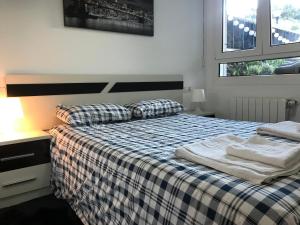 een slaapkamer met een bed met een geruite deken bij Apartamento Libertad in Castro-Urdiales
