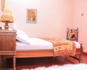 a bedroom with a bed and a table and a lamp at Nyahururu Highlands Heaven -BnB in Nyahururu
