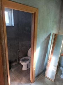 a bathroom with a toilet and a mirror at Sumeru in Senmonorom