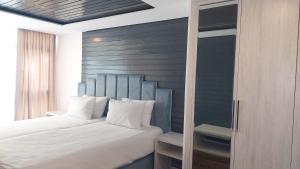 a bedroom with a white bed with a blue headboard at Basharu resort in Lankaran
