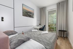 a bedroom with two beds and a desk and a window at Pobierowo Plaża & SPA - Apartament na Wydmach by Renters in Pobierowo