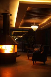 a living room with a fireplace and a chandelier at PAZARCIK MOUNTAIN HOTEL in Trabzon