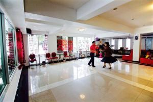 two people are standing in a room with a lobby at Latin Garden Hotel in Bangkok