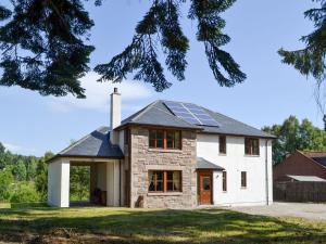 a house with solar panels on the roof at Battanropie Lodge in Carrbridge