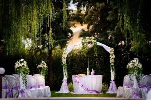 una mesa con sillas blancas y una mesa con flores en Complex Racic, en Voyvodinovo