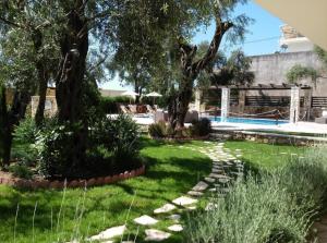 a garden with trees and a swimming pool at Vassilis Guest House in Parga