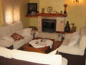 a living room with two couches and a fireplace at Hotel Rural El Museo in Cedillo de la Torre