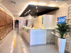 a woman sitting at a counter in a kitchen at Urban Sea Hotel Atocha 113 in Madrid