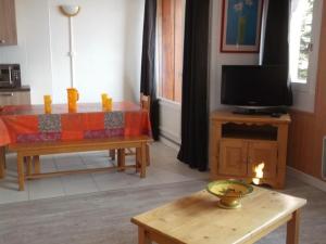 a living room with a table and a television at Appartement Orcières Merlette, 3 pièces, 8 personnes - FR-1-262-92 in Forest des Baniols