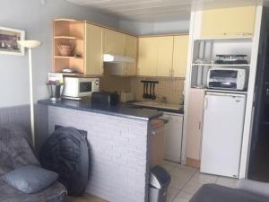 a small kitchen with a white refrigerator and a counter at Appartement Arette, 1 pièce, 6 personnes - FR-1-602-44 in Arette