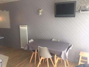 a table with chairs and a tv on a wall at Appartement Arette, 1 pièce, 6 personnes - FR-1-602-44 in Arette