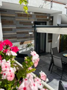 a patio with pink flowers in front of a building at La Casa di Giò - Free Space n26 in Nicolosi