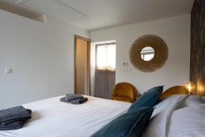 1 dormitorio con cama y espejo en la pared en Le Presbytère de Sautour, en Sautour