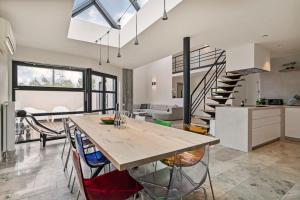 a kitchen and living room with a table and a staircase at Schitterende loft met jacuzzi en sauna in Mechelen in Mechelen