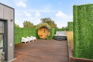 a garden with a fence and a wooden patio at Schitterende loft met jacuzzi en sauna in Mechelen in Mechelen