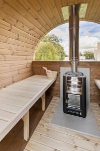 a sauna with a stove in a wooden building at Schitterende loft met jacuzzi en sauna in Mechelen in Mechelen
