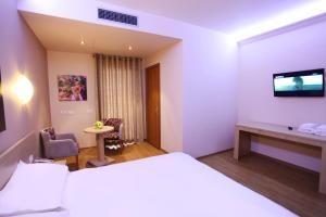 a hotel room with a bed and a tv at Hotel Green in Tirana