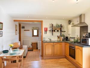a kitchen with wooden cabinets and a table in a room at The Stables Studio in Haydon Bridge