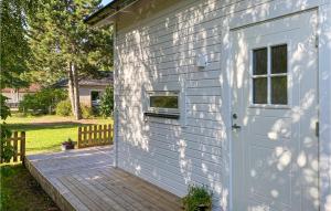ein weißes Haus mit einer Tür und einer Terrasse in der Unterkunft Beautiful Home In Gotlands Tofta With Kitchen in Gnisvärd