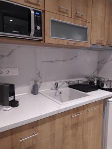 eine Küche mit einer Spüle und einer Mikrowelle in der Unterkunft Flâneur apartments in Ormos Panagias